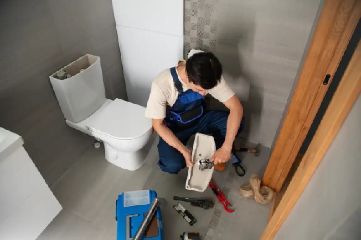 Veterans Heating and Cooling, Plumbing, and Electrical technician working on a toilet.